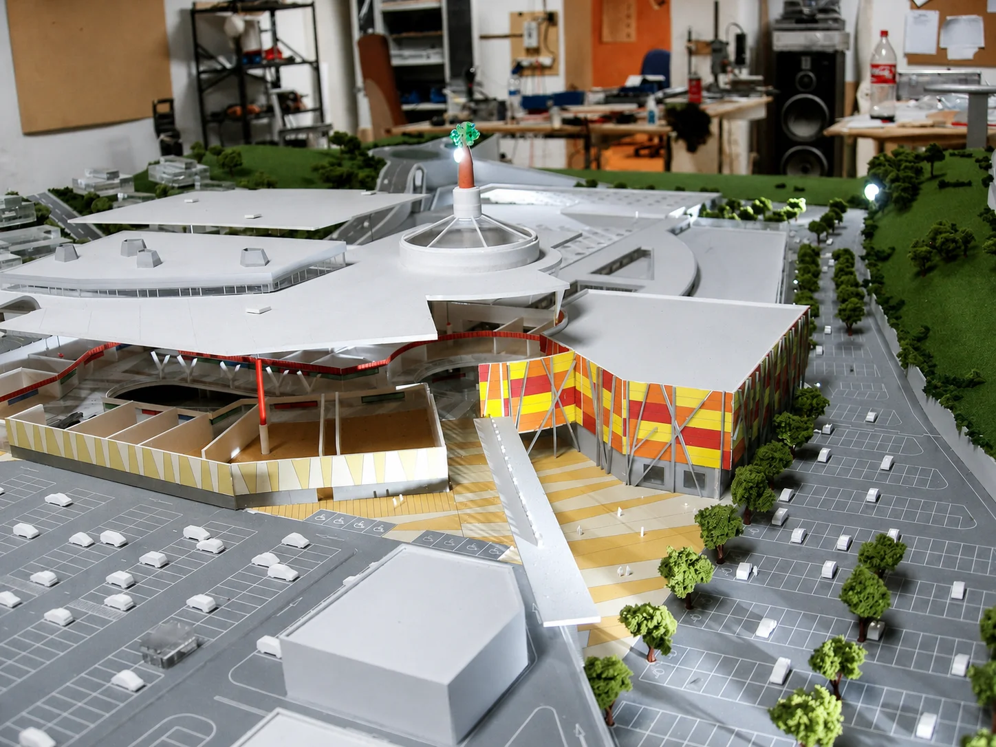 Maqueta del Centro Comercial Versalia con plaza central y fachada de franjas